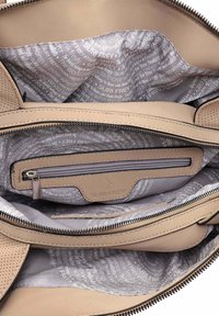 Beige leather handbag interior with multiple compartments, silver zipper, and a lined fabric featuring repeating text pattern.