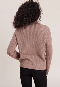 Strickpullover in hellem Taupe mit gerippter Struktur, rundem Ausschnitt und offenen Maschendetails an den Ärmeln. Keine sichtbaren Verschlüsse oder Muster.