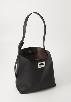 Schwarze Leder-Bucket-Bag mit verstellbarem Schulterriemen und silberner rechteckiger Schnalle auf einfarbigem hellem Hintergrund.