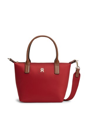 Sac à main rouge avec des anses en cuir marron et une bandoulière amovible en tissu rouge, avec un petit logo doré au centre.