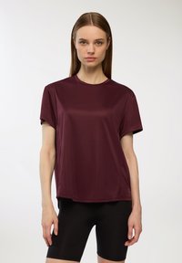 Burgundowa koszulka sportowa z okrągłym dekoltem, krótkimi rękawami i luźnym krojem, wykonana z gładkiego, lekkiego materiału.