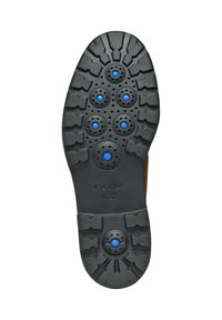 Suola di scarpa in gomma nera con grip testurizzato, caratterizzata da sei aperture circolari blu e un'area centrale liscia. Logo "GEOX" in rilievo.
