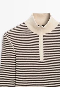 Maglione a righe con colletto alto in tonalità beige e marrone, caratterizzato da una zip frontale e una texture a costine. Dettagli nella zona del colletto.