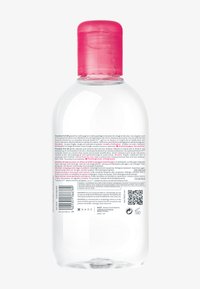 Bouteille en plastique transparent avec un bouchon à bascule rose, contenant un liquide transparent. L'étiquette arrière présente un texte multilingue et un code QR.