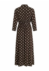 Vestido largo marrón con lunares blancos, mangas tres cuartos, cuello y una cintura elástica para dar forma. Textura de tela suave.