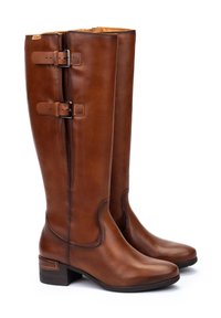 Bottes en cuir marron hautes jusqu'aux genoux avec deux boucles réglables sur le côté et des talons bas empilés, présentées sur un fond blanc.
