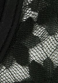 Schwarzer Spitzenstoff zeichnet sich durch ein netzartiges Design mit herzförmigen Mustern aus, ergänzt durch glatte schwarze Kanten.