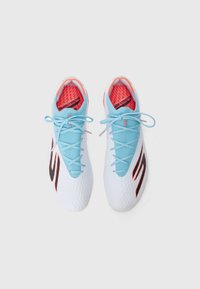 Football shoes with a white textured upper, blue laces, and pink accents. Features a black logo on the side and a padded insole.