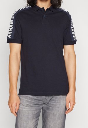 Polo bleu marine avec patte de boutonnage à deux boutons, manches courtes avec le logo blanc "ARMANI EXCHANGE" le long des épaules, en coton.