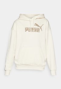 Kremowa bluza z kapturem, z kangurzą kieszenią z przodu, sznurkiem do regulacji kaptura oraz brązowym graficznym logo na klatce piersiowej z sylwetką skaczącego pumy.