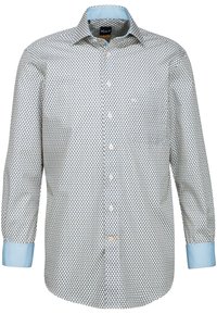 Camicia a maniche lunghe con bottoni di colore azzurro chiaro, con un motivo geometrico bianco e blu navy, caratterizzata da un colletto e polsini di un azzurro chiaro a contrasto.