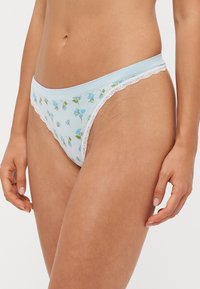 Light blue cotton panties with floral embroidery in blue and green. Delicate lace trim along the edges enhances the design.