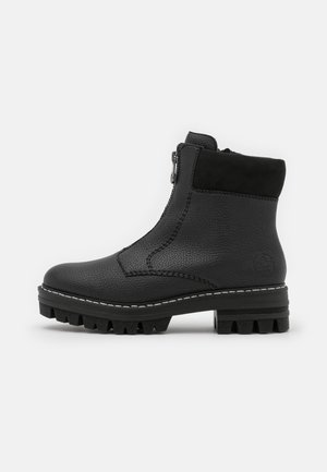 Bottine en cuir noir avec semelle texturée, fermeture éclair latérale, col rembourré et coutures blanches autour de la semelle, adaptée à un usage robuste.