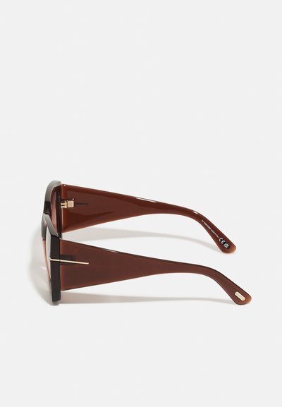 Brown sunglasses with a geometric design, featuring thick black rims and smooth, glossy brown temples. Minimal gold accents on the temples.