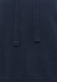 Maglione navy in tessuto morbido, con due stringhe a tracolla lavorate a maglia e orlo a costine. Design semplice, senza ulteriori motivi o dettagli.