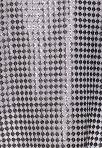Silber- und schwarz gemusterter Stoff mit einem Gitter aus kleinen floralen Formen, einer glänzenden metallischen Textur und einem glatten, leichten Erscheinungsbild.