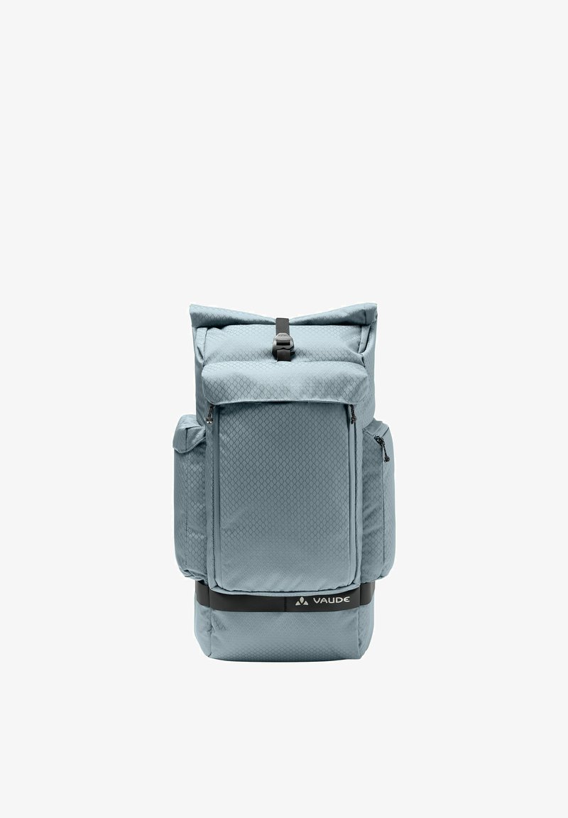Sac à dos Vaude bleu clair avec plusieurs compartiments zippés, une fermeture à boucle supérieure et une surface en tissu texturé.