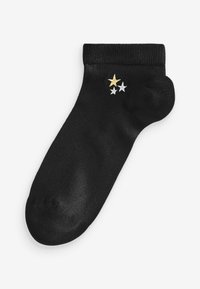 Schwarze Socke aus glattem Stoff. Mit goldenen und silbernen Sternstickereien. Knöchelhöhe mit geripptem Bündchen. Rundes Zehendesign.