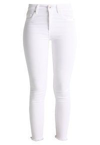 Jean skinny blanc avec une texture de tissu lisse, taille haute, design à cinq poches et ourlets effilochés au niveau de la cheville.