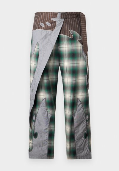 Φαρδιά παντελόνια με πράσινο και άσπρο καρό, καφέ ριγέ ζώνη και γκρι αφηρημένα μπαλώματα που μοιάζουν με φλόγες στα πόδια και στην περιοχή της μέσης.