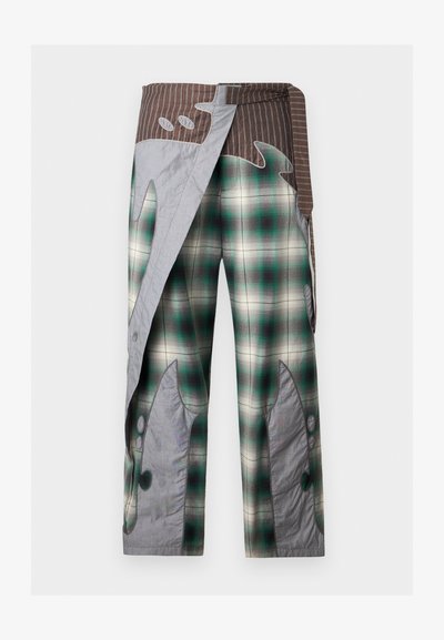 Φαρδιά παντελόνια με πράσινο και άσπρο καρό, καφέ ριγέ ζώνη και γκρι αφηρημένα μπαλώματα που μοιάζουν με φλόγες στα πόδια και στην περιοχή της μέσης.