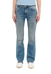 Vaqueros de mezclilla azul claro con corte recto, textura descolorida, cinco bolsillos y detalles de costura naranja. Combinados con zapatos blancos.