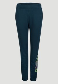 Námořnické modré tepláky s elastickým pasem, dvěma bočními kapsami a barevným logem potištěným na levé nohavici. Zúžený střih nohavic.