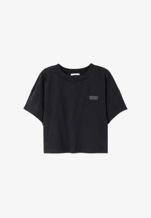 Čierne skrátené tričko z mäkkej bavlny. Má okrúhly výstrih, voľné krátke rukávy a malý text loga na hrudi.