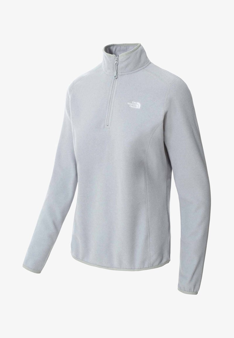 Pull polaire gris clair à manches longues, zip jusqu'au quart, avec le logo The North Face sur le côté gauche de la poitrine.