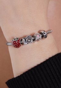 Zilveren bedelarmband met een rode emaille aardbei, een zilveren camera, een klein roze hartje en een zilveren kraal met een glanzende afwerking.