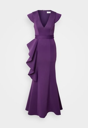 Μωβ βραδινό φόρεμα με βαθύ V ντεκολτέ, κοντά μανίκια και ριχτό προεξέχον μέρος στο πλάι. Φτιαγμένο από λείο, εφαρμοστό ύφασμα, ανοίγει στο τελείωμα.