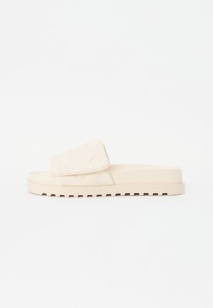 Beige slidssandal med tyk sål og bred rem med fine præget mønstre.