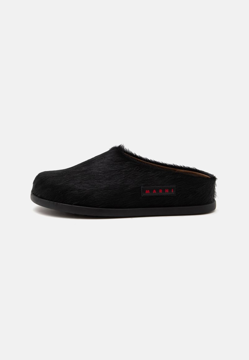 Μαύρο παντόφλα τύπου slip-on με χνουδωτή υφή και μικρή ορθογώνια ετικέτα με την ένδειξη «MARNI» με κόκκινα γράμματα στο πλάι.