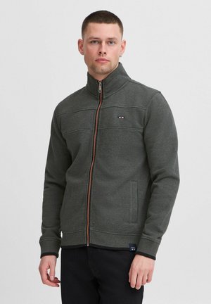 Graue Zip-Jacke mit hohem Kragen, zwei Fronttaschen und einem akzentuierenden Reißverschluss. Verfügt über ein Logo auf der Brust mit horizontalen Steppdetails.