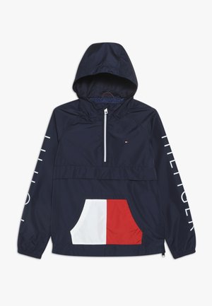 Granatowa kurtka z kapturem, z półzamkiem, przednia kieszeń w kolorze białym i czerwonym oraz białe napisy "HILFIGER" na rękawach.