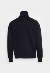 Sudadera de manga larga azul marino con cuello alto, puños y dobladillo acanalados, mostrada desde la parte posterior sobre un fondo blanco plano.