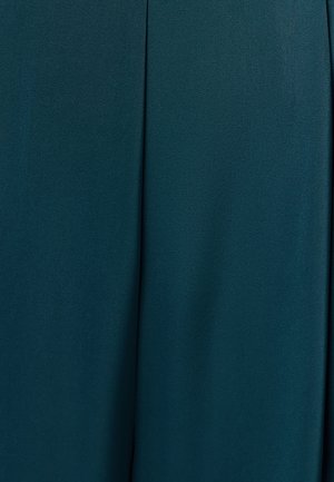 Tumši teal audums ar gludu tekstūru un izteiktu vertikālu šuvi, kas iet caur centru.