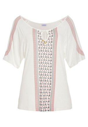 Witte tuniektop met korte mouwen, een V-hals met striksluiting, en geborduurde bloemenpatronen in rood, groen en zwart langs de voorkant.