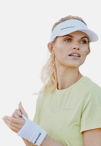 Witte zonnebril met "ENDURANCE" branding, lichtgroene sportshirt, witte polsband, textielstof, rechte snit, minimaal ontwerp.
