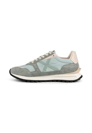 Zapatilla gris y azul claro con cordones, detalles en ante y tela, acentos beige y suela gruesa de goma negra.