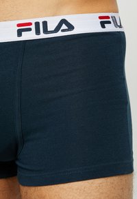 Granatowe bawełniane bokserki z białą elastyczną talią z czerwonym i czarnym logo Fila. Gładka struktura i dopasowany krój.
