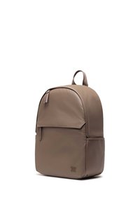 Brown backpack with a smooth texture, rounded shape, zippered top, front pocket, and a top handle. Features a logo in the lower corner.