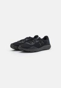 Un paio di scarpe da corsa nere Under Armour con tomaia in rete e design con lacci, mostrate su uno sfondo bianco.