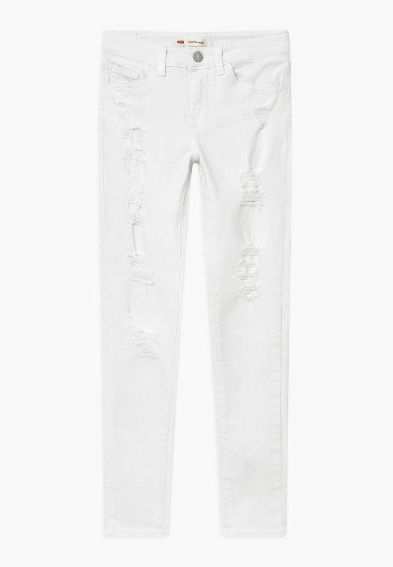 Vaqueros pitillo de denim blanco con múltiples desgastes y bordes deshilachados. Cuenta con una cinturilla estándar y un diseño de cinco bolsillos.