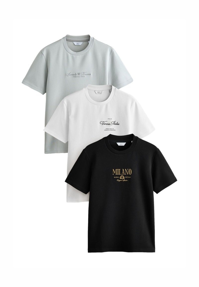 Három rövid ujjú póló egymáson: halvány zöld, fehér és fekete. Mindegyiken ellentétes színű felirat található, a fekete pólón arany betűkkel.