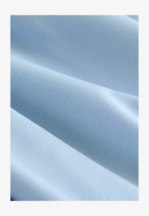 Svijetloplavi materijal s glatkom teksturom, s finim uzorkom tkanja. Nabranosti ističu njegovu meku draperiju i ujednačenu boju.