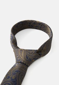 Μπλε μεταξωτή γραβάτα σε ναυτικό χρώμα με χρυσό σχέδιο paisley, καλοδεμένη και τοποθετημένη σε βρόχο σε λευκό φόντο.