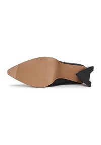 Chaussure noire à bout pointu avec une semelle texturée couleur tan et un talon bloc noir à forme unique, vue par le dessous.