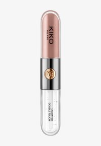 Lippenprodukt in einem transparenten Röhrchen mit einem abgerundeten roségoldenen Deckel, der einen silbernen Mittelteil und fetten schwarzen Text auf dem Etikett aufweist.