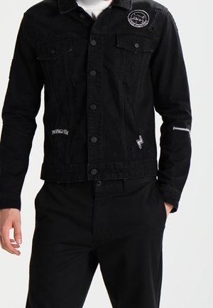 Zwarte denimjas met twee borstzakken, knoopsluiting en geborduurde details. Het ontwerp bevat een witte logo-accent en een geweven afwerking.